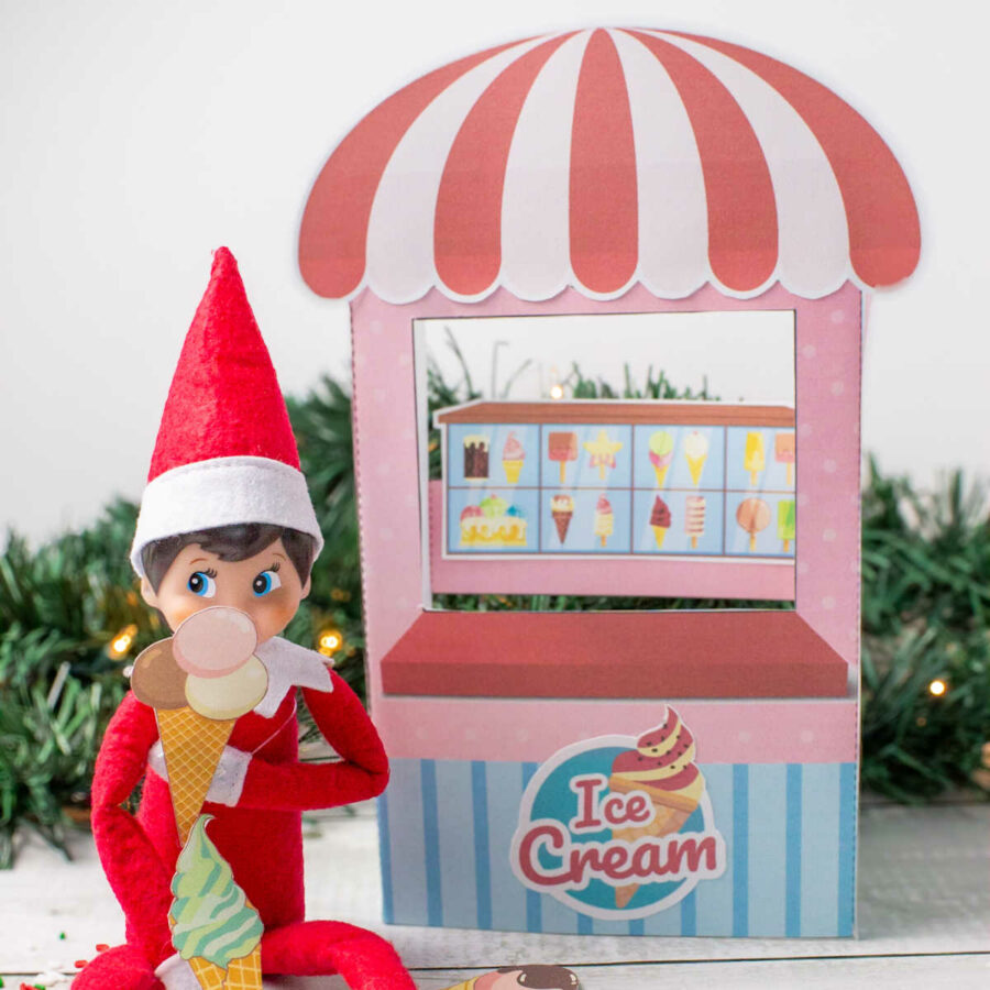 An elf sitting next to a printable elf ice cream shop eating ice cream