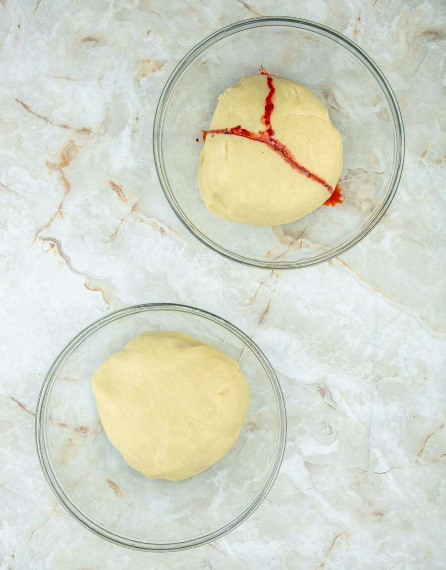 Cookie dough divided in two portions; one with red food coloring.