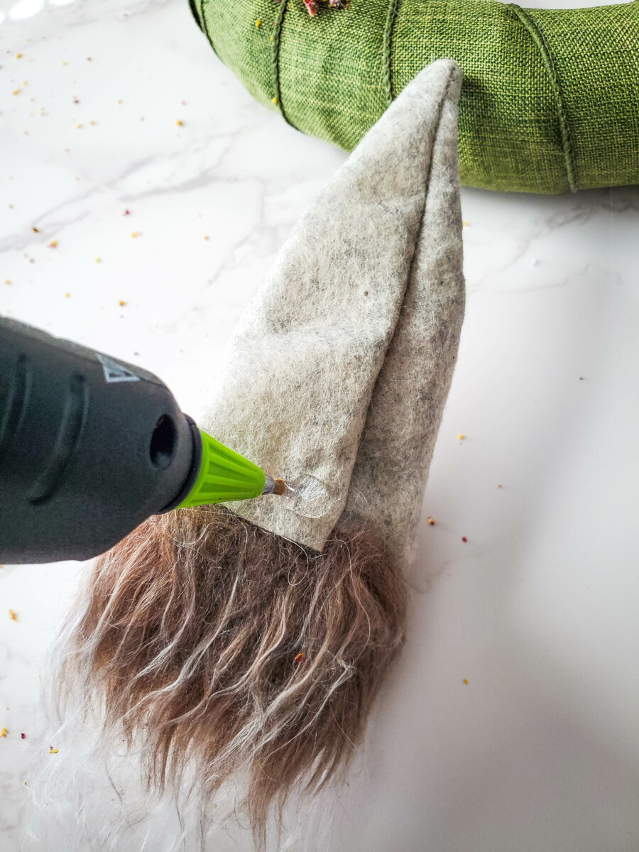 Adding hot glue to the back of a gnome