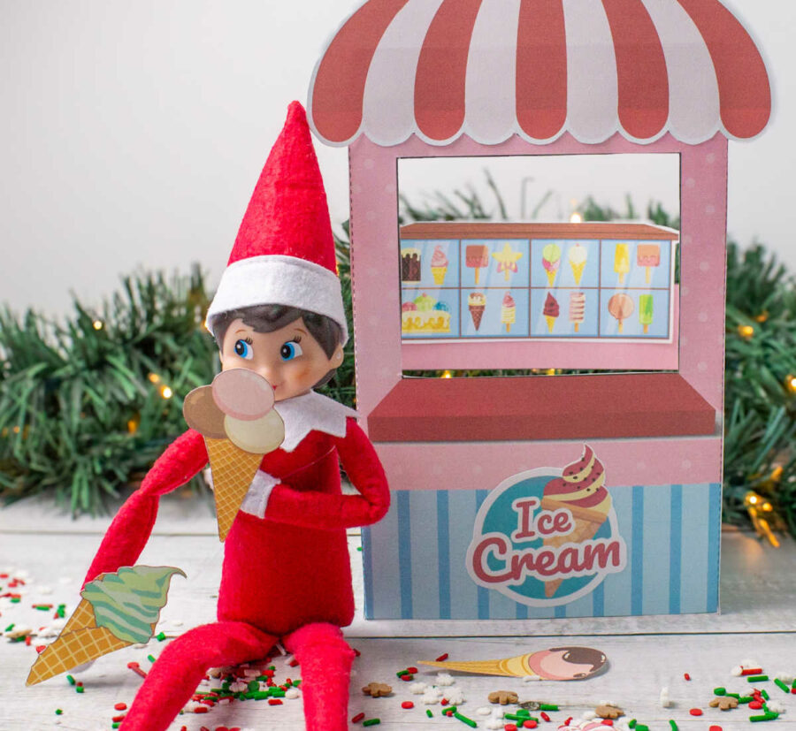 An elf sitting next to the ice cream shop with ice cream cones in his hands