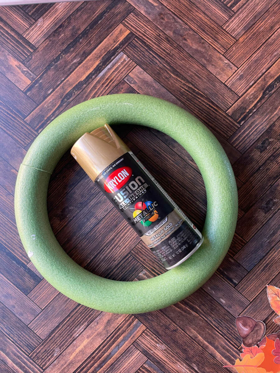 Green styrofoam wreath form with gold spray paint in the middle