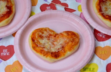 Looking for a fun Valentine's Day recipe to make with the kids? Check out these easy mini heart shape pizzas made with cookie cutters!