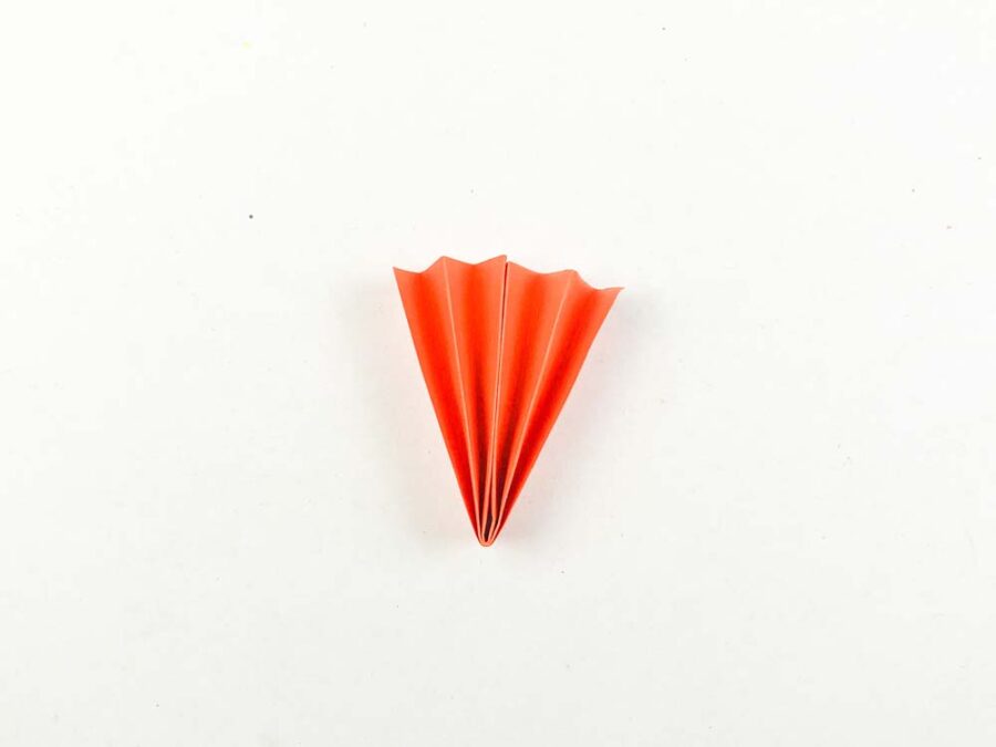 Orange paper accordion folded completely in half