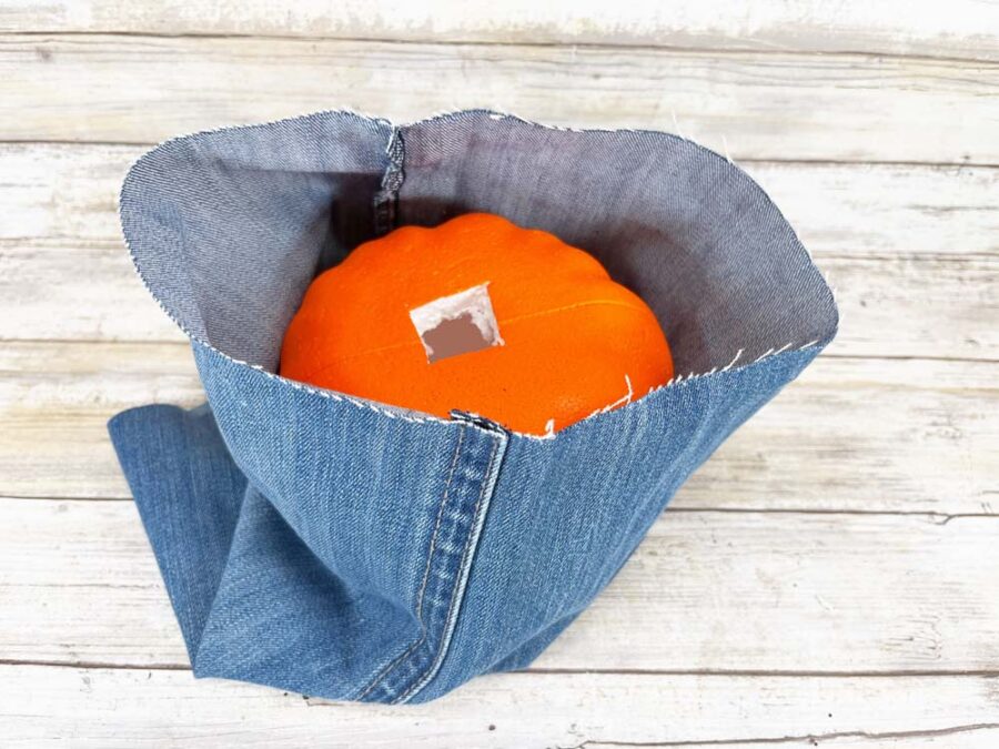 Foam pumpkin inside the leg of cut up jeans