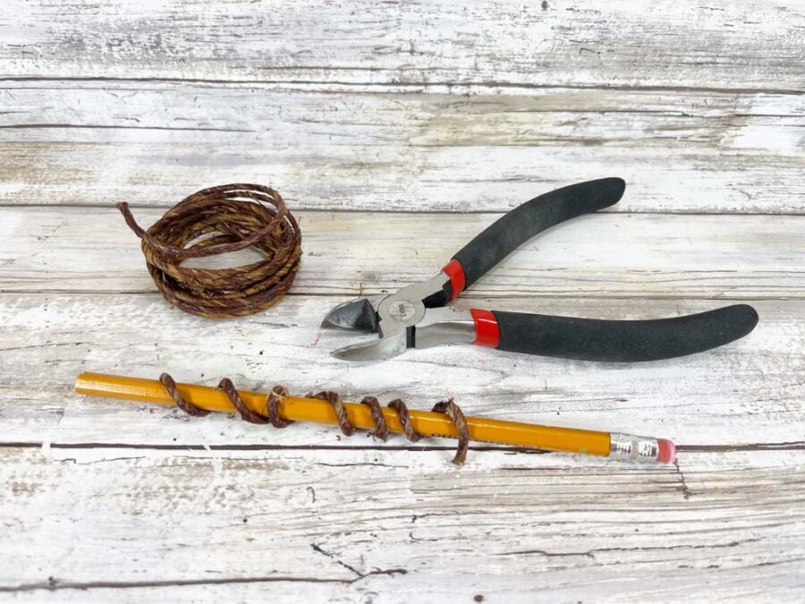 Wired twine, wire cutters, wired twine wrapped around a pencil