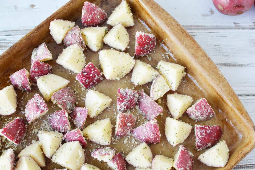 red potatoes coated in Parmesan cheese and dry ranch dressing on a baking sheet