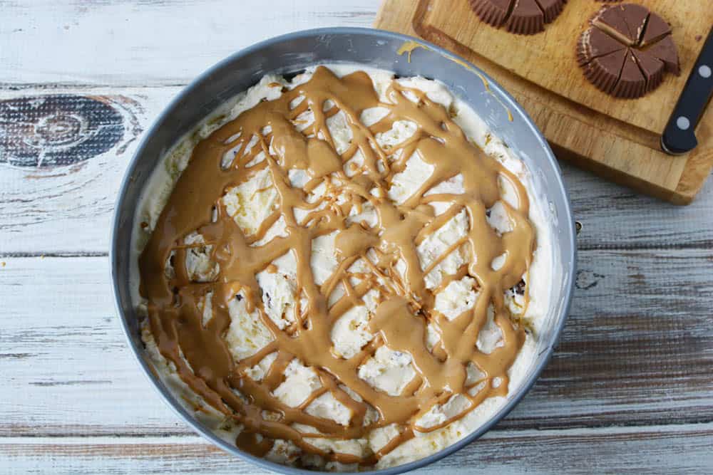 Ice cream in a cake pan drizzled with peanut butter