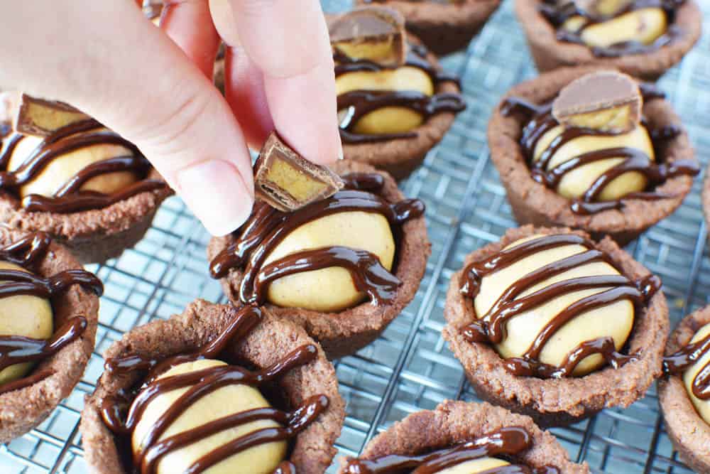 Putting candy on top of finished cookie cups