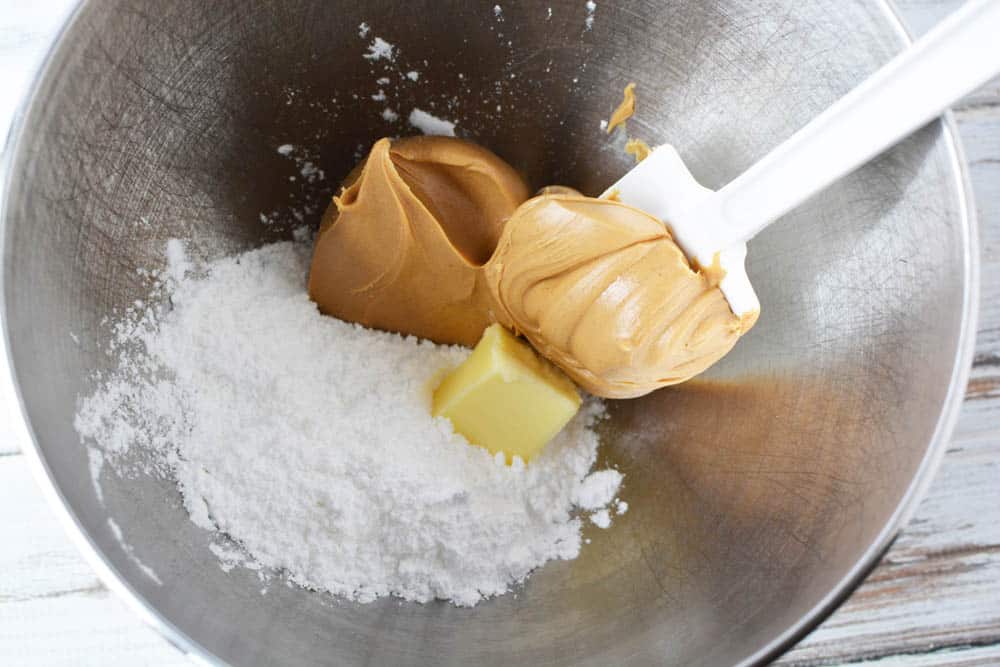 peanut butter, powdered sugar, and butter in a mixing bowl