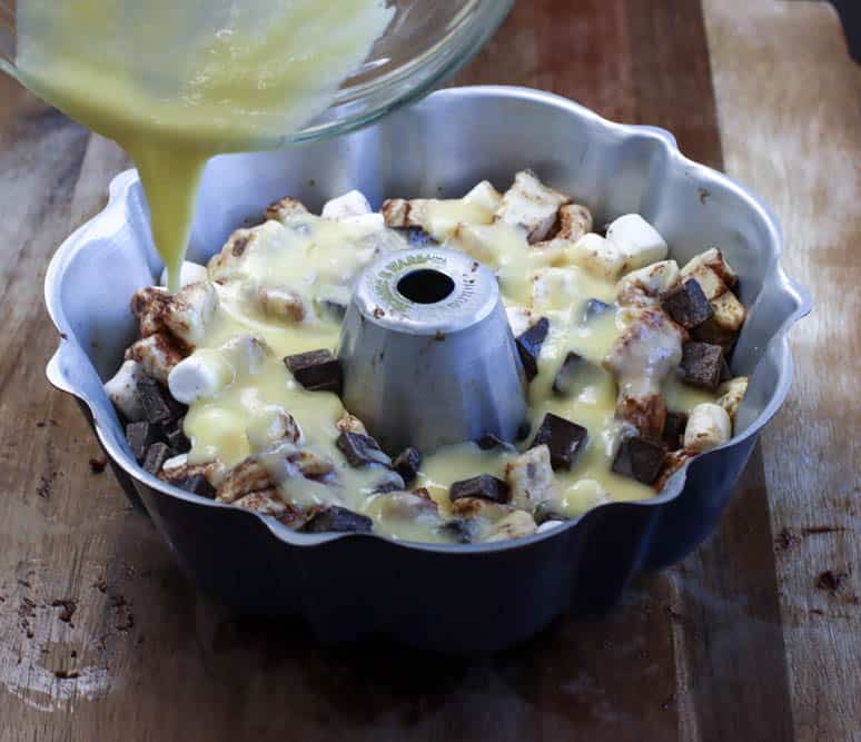 Egg and butter mixture being poured over an unbaked s'mores monkey bread