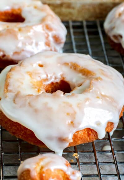 Glazed sour cream donuts on a cooling rack