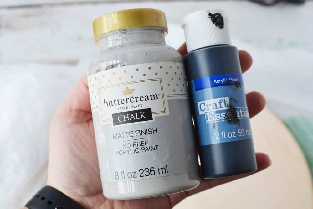 gray chalk paint and black acrylic craft paint in a person's hand