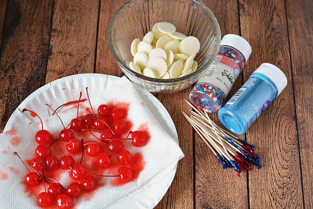 Maraschino cherries, white chocolate wafers, sprinkles, and toothpicks